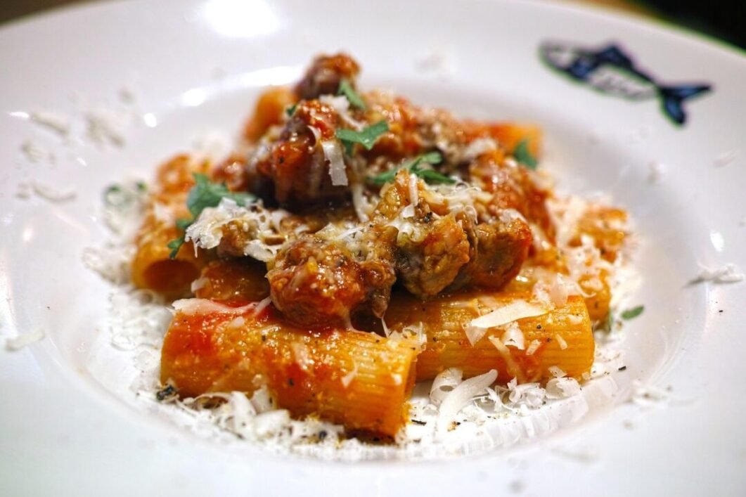 Creamy tomato rigatoni pasta dish garnished with fresh basil