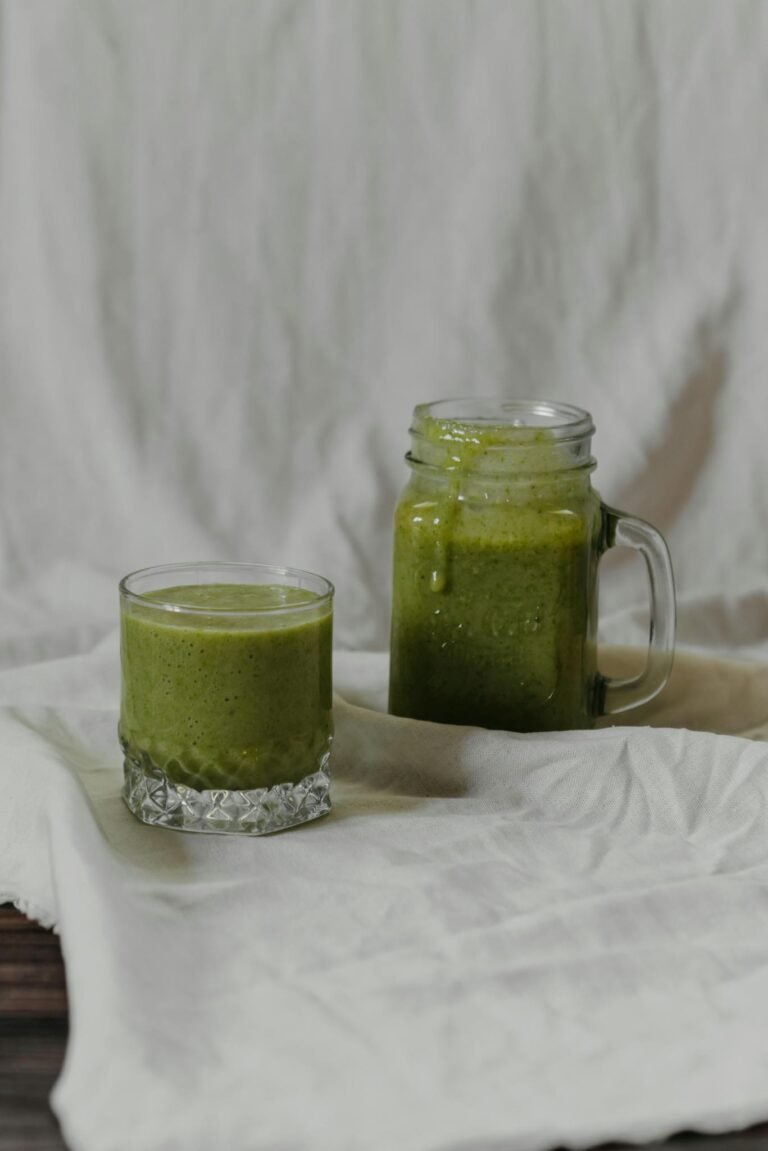 Inviting green smoothie served in a glass and jar, perfect for a healthy lifestyle.