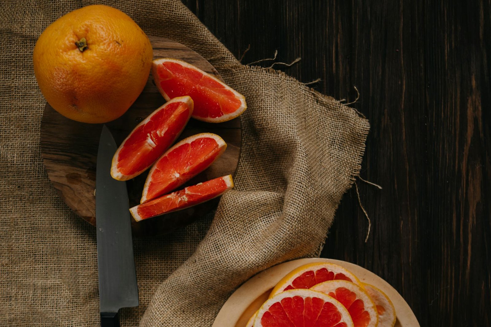 Sliced grapefruit on a wooden table, perfect for healthy eating and wellness themes.